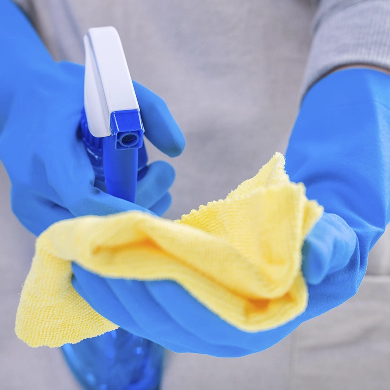 manos sujetando pulverizador y bayeta