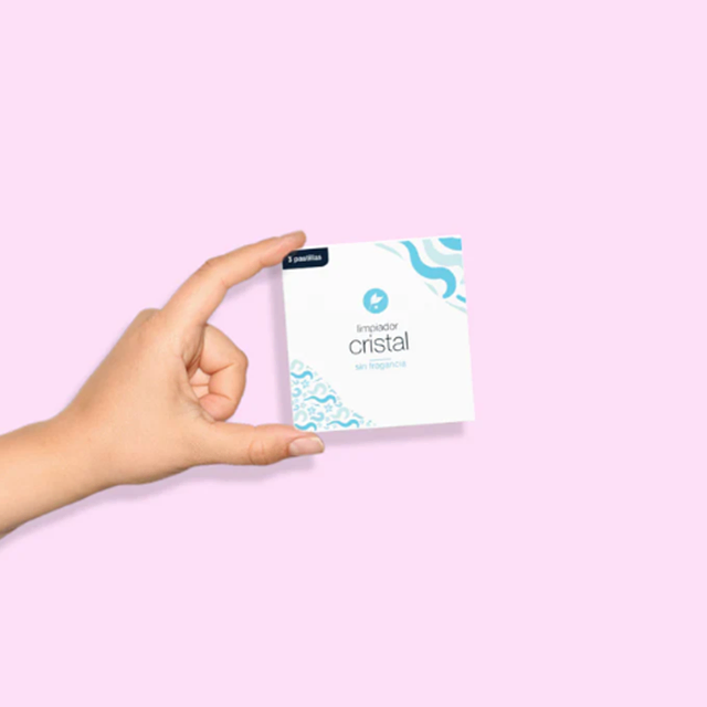 mano sujetando caja de pastillas de limpieza